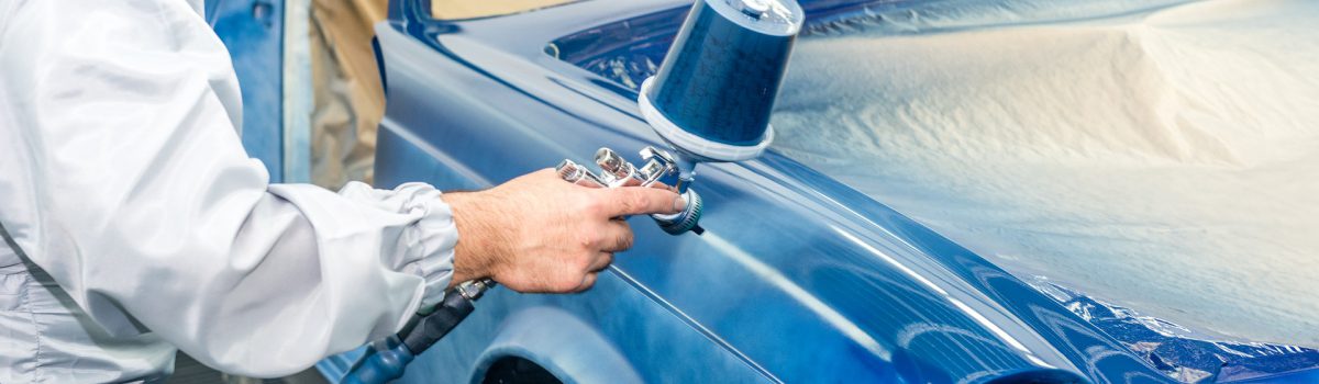 man spray painting a car